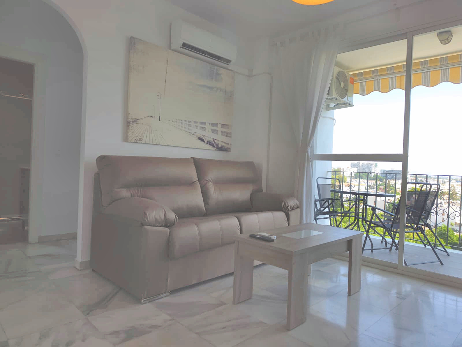 Salón con salida a terraza y vistas al mar en un apartamento turístico de Torremolinos
