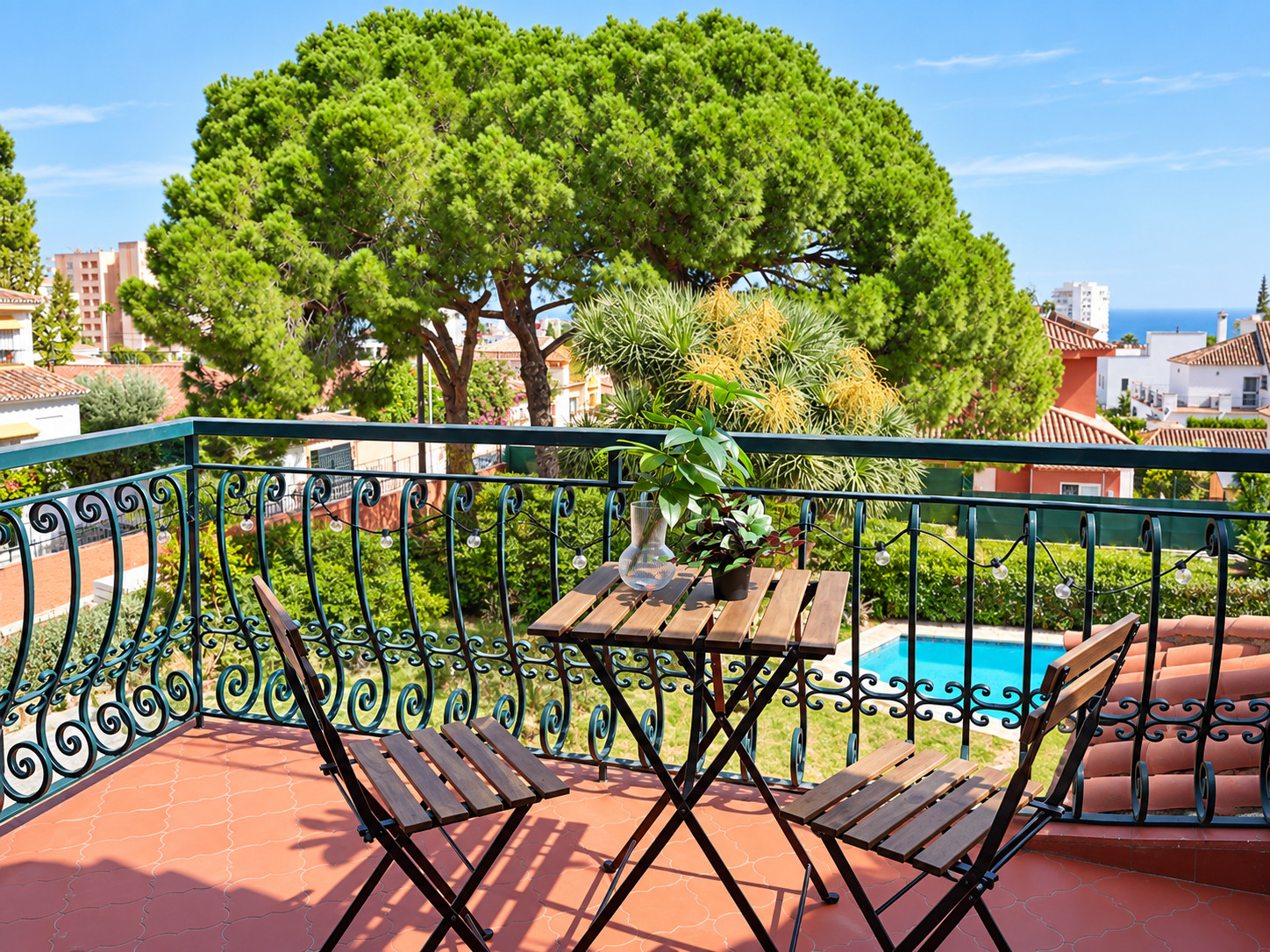 Terraza con piscina en Benalmádena Terraza soleada con mesa y sillas sobre la piscina de un apartamento turístico en Benalmádena